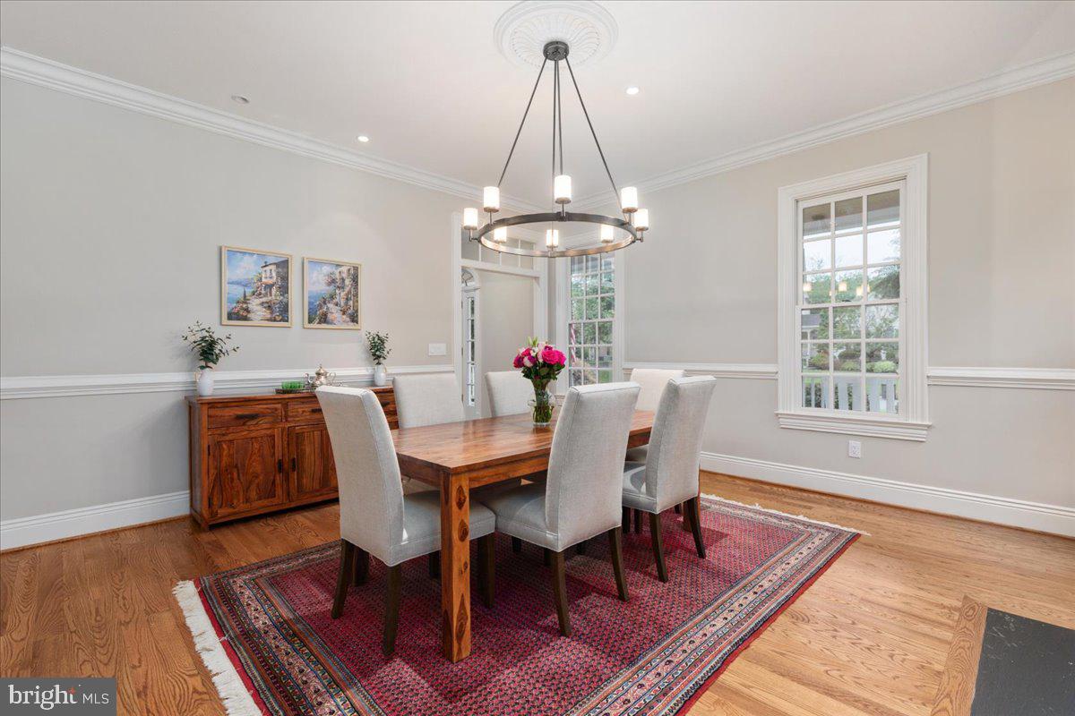 14915 Alpine Bay Loop Gainesville, VA 20155 - Photo 14 of 105 a dining room with wooden floor a chandelier a wooden table and chairs