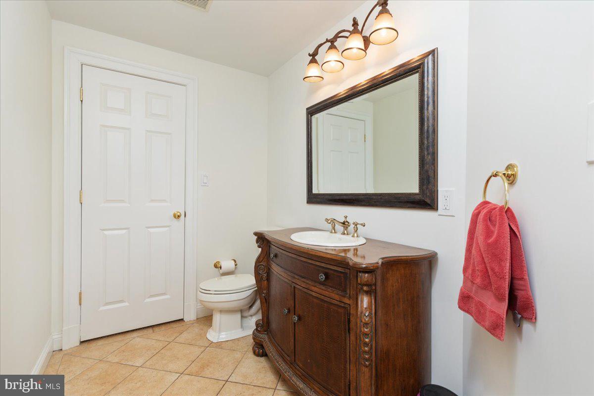 14915 Alpine Bay Loop Gainesville, VA 20155 - Photo 67 of 105 a bathroom with a toilet sink vanity and mirror