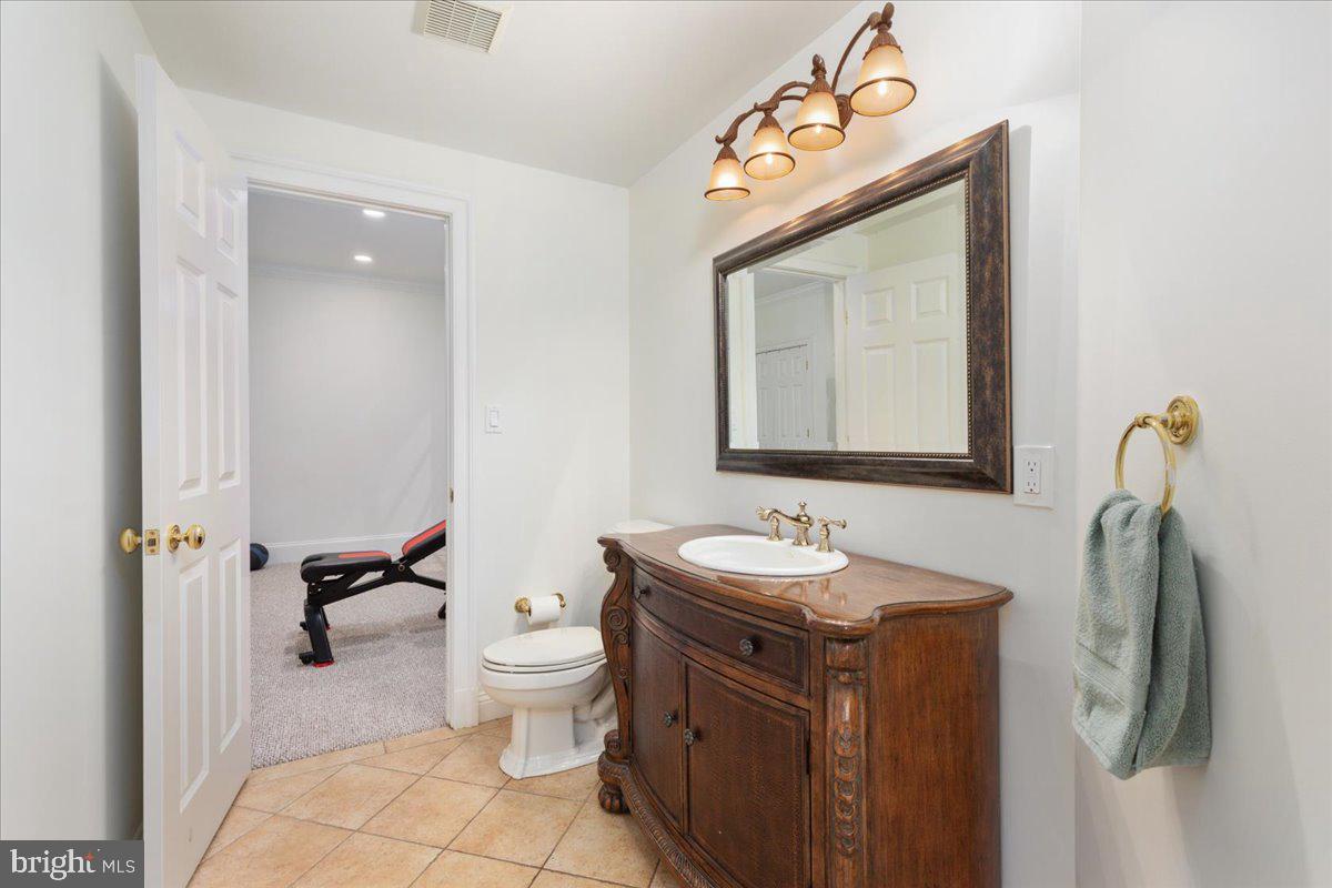 14915 Alpine Bay Loop Gainesville, VA 20155 - Photo 68 of 105 a bathroom with a toilet sink and mirror