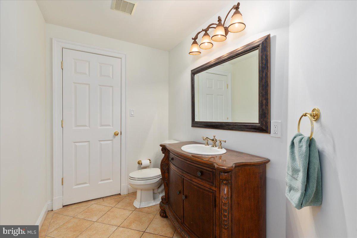 14915 Alpine Bay Loop Gainesville, VA 20155 - Photo 69 of 105 a bathroom with a sink a toilet and mirror