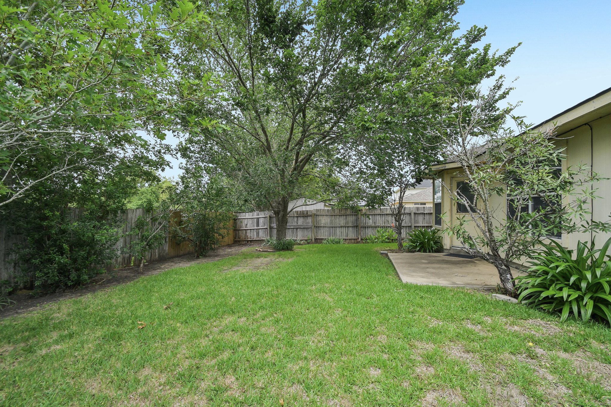 610 Lavaca Loop Elgin, TX 78621 - Photo 36 of 37 A well-maintained lawn and concrete patio provide ample outdoor space for relaxation.