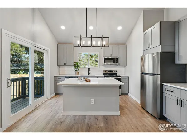 a kitchen with stainless steel appliances kitchen island a refrigerator sink and cabinets