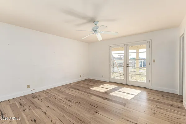 an empty room with wooden floor and windows