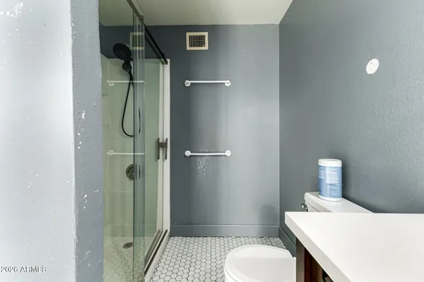 a bathroom with a granite countertop sink toilet and shower