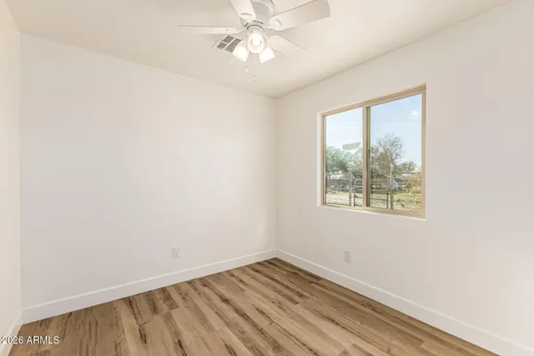 an empty room with a window and a fan