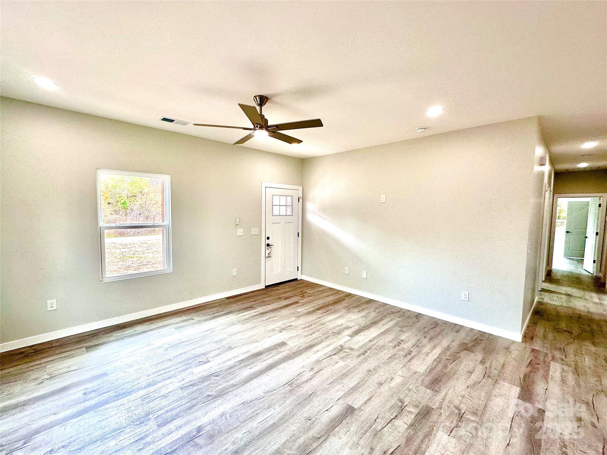 1171 Peach Orchard Road Jefferson, SC 29718 - Photo 3 of 30 wooden floor in an empty room with a window