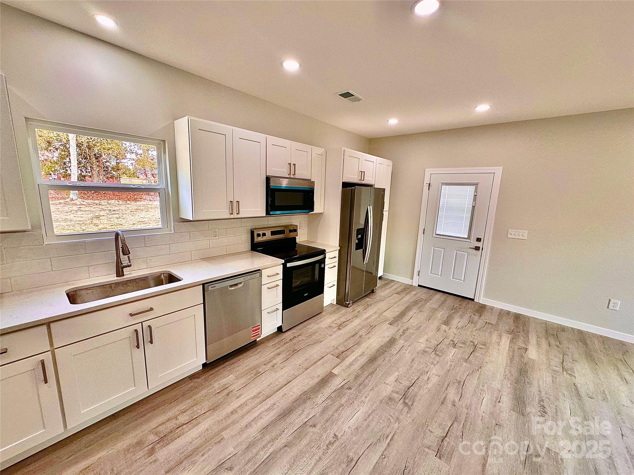 1171 Peach Orchard Road Jefferson, SC 29718 - Photo 4 of 30 a kitchen with white cabinets and appliances