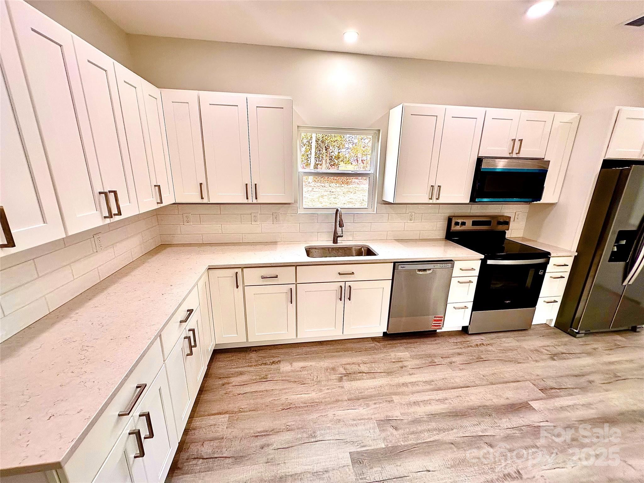 1171 Peach Orchard Road Jefferson, SC 29718 - Photo 8 of 30 a kitchen with a sink stove and white cabinets