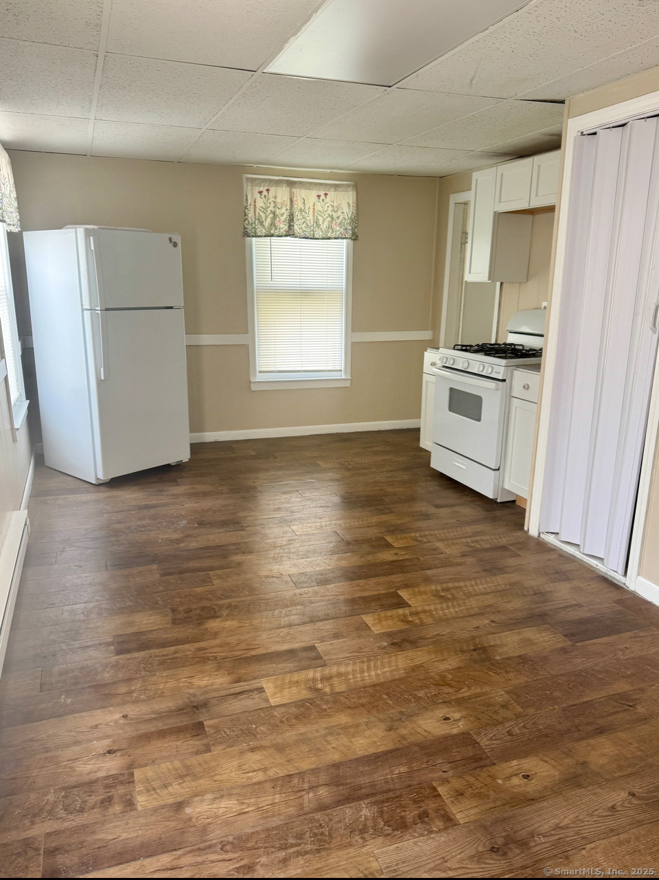 a view of a kitchen with microwave and refrigerator