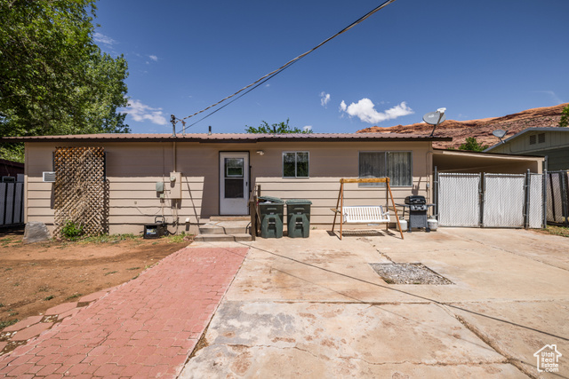 527 Palisade Drive Moab, UT 84532 - Photo 26 of 51 View of rear facade with fence, a carport, and a gate