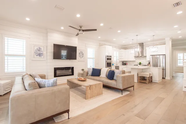 a living room with furniture kitchen view and a flat screen tv