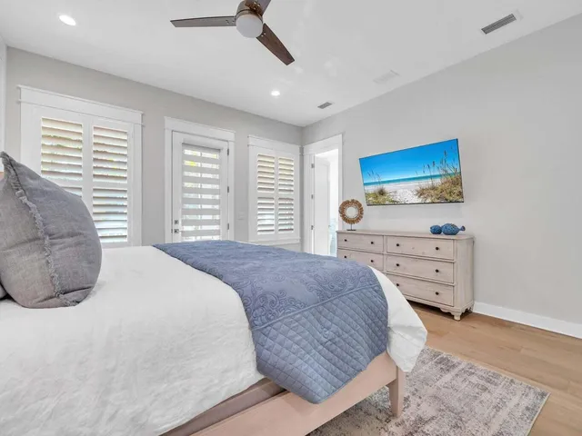 a bedroom with a large bed and a lamp on dresser