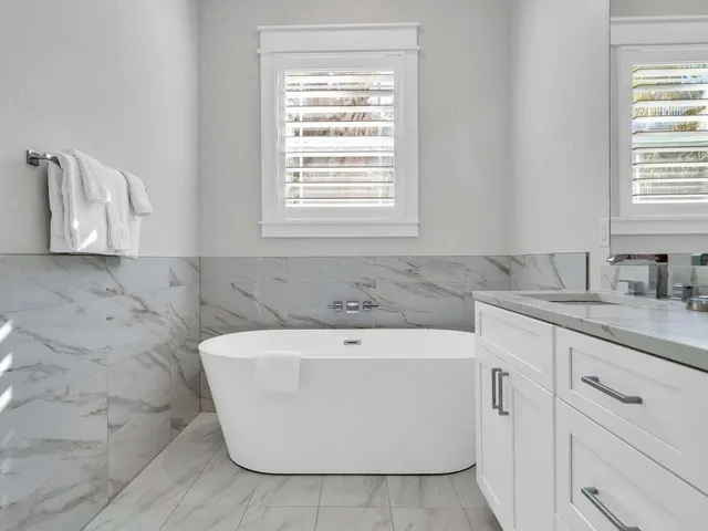 a bathroom with a granite countertop sink a toilet and a bathtub