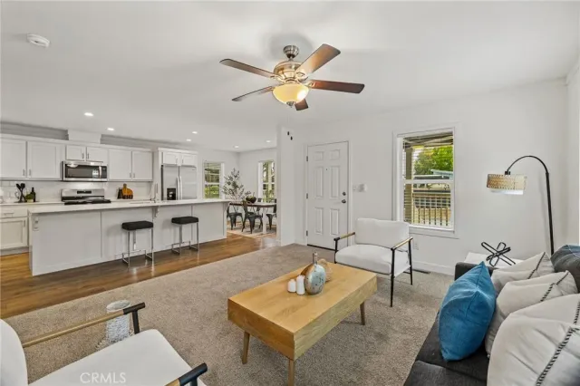 a living room with furniture kitchen view and a window