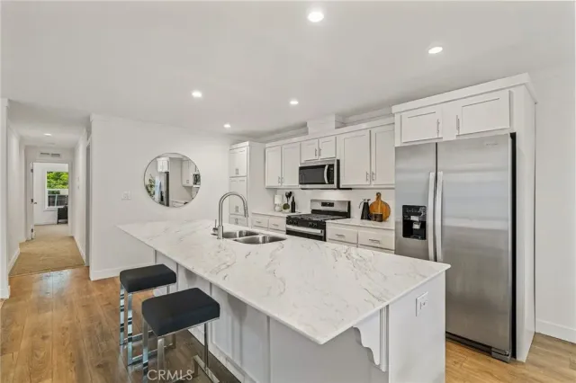 a kitchen with stainless steel appliances granite countertop a sink a stove and a refrigerator