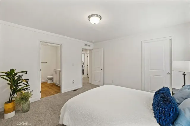 a bedroom with a bed and a potted plant