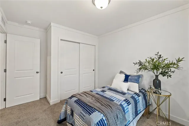 a bedroom with a bed and a potted plant