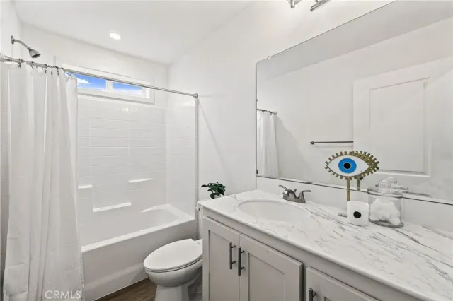 a bathroom with a granite countertop sink a toilet a shower and a mirror