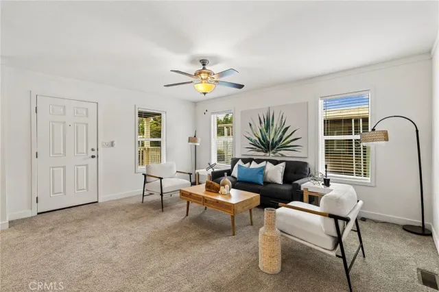 a living room with furniture a ceiling fan and a window