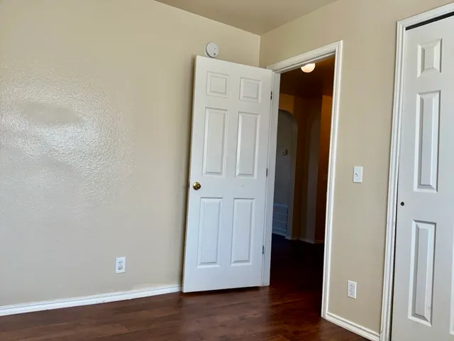 an empty room with wooden floor and closet
