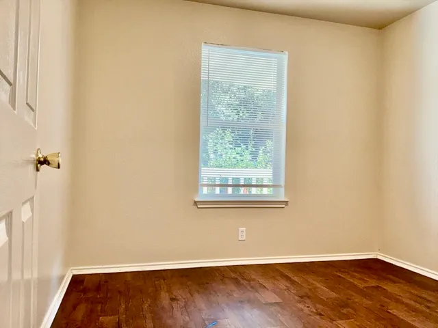 an empty room with wooden floor and a window