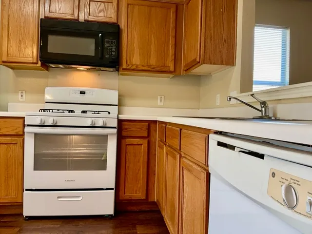 a kitchen with granite countertop cabinets stainless steel appliances and wooden cabinets