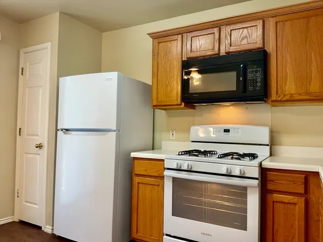 a kitchen with granite countertop cabinets stainless steel appliances and a wooden floor