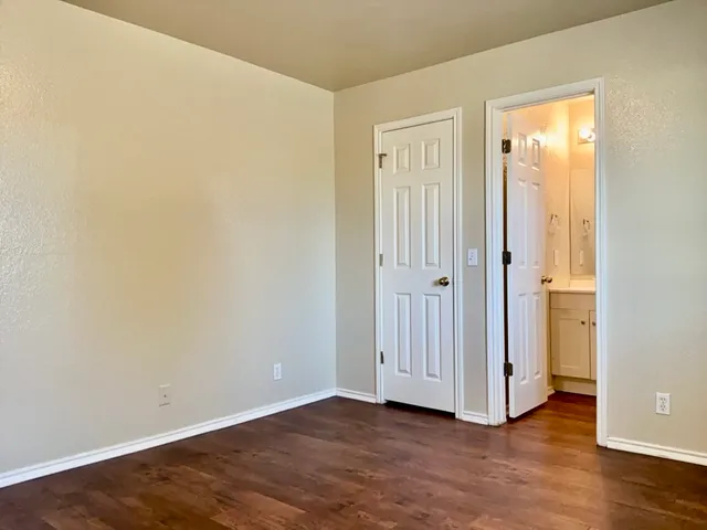 an empty room with wooden floor and closet area