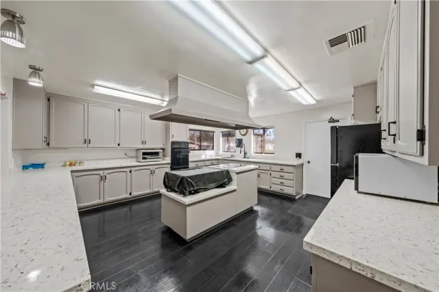 a kitchen with stainless steel appliances a stove a sink and white cabinets