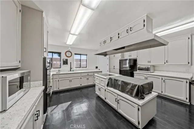 a kitchen with granite countertop white cabinets and white appliances