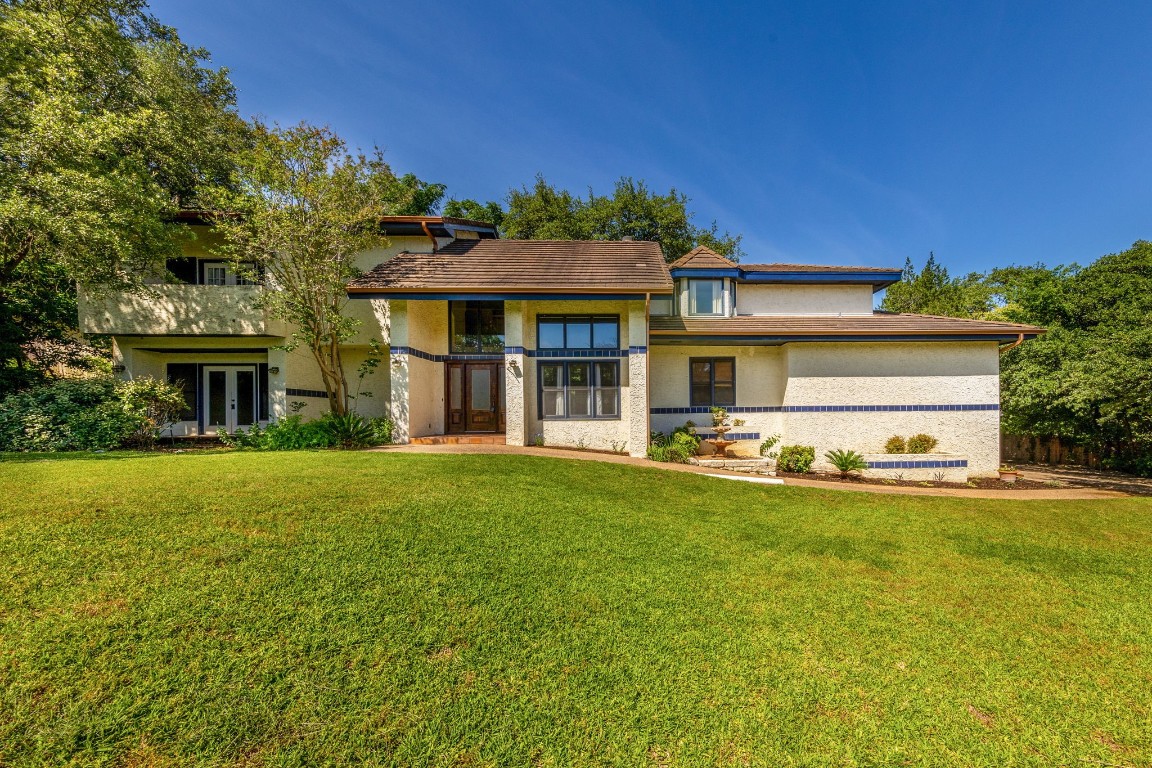 a view of a house with a yard and sitting area