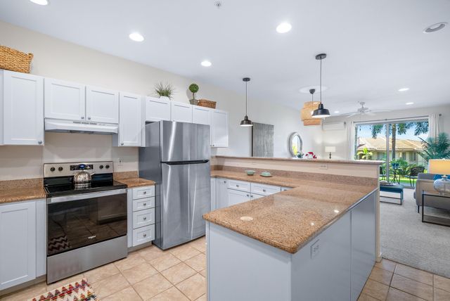 a kitchen with stainless steel appliances granite countertop a stove a sink a refrigerator and a refrigerator