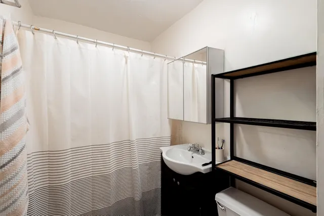 a bathroom with a sink toilet and a shower curtain