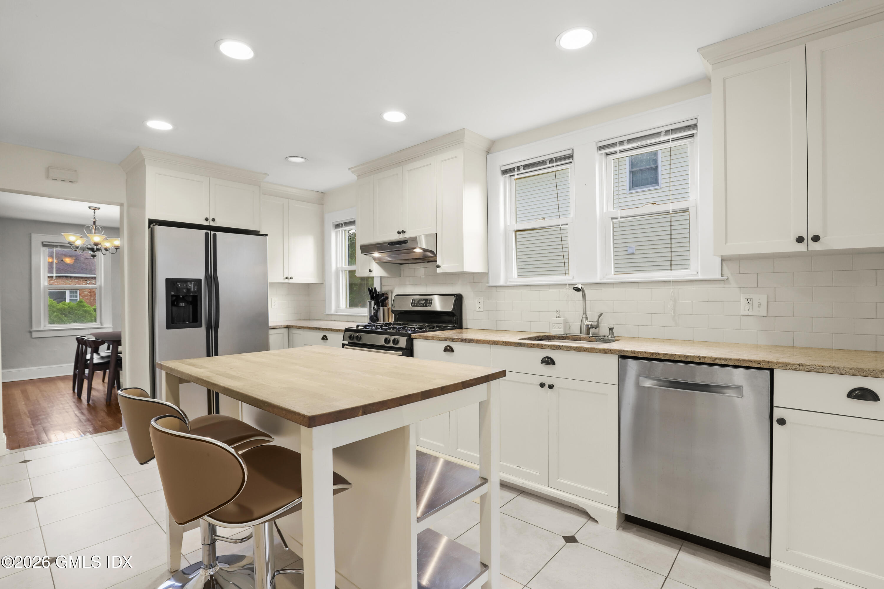 11 Rex Street Greenwich, CT 06831 - Photo 5 of 22 a kitchen with a table chairs refrigerator and cabinets
