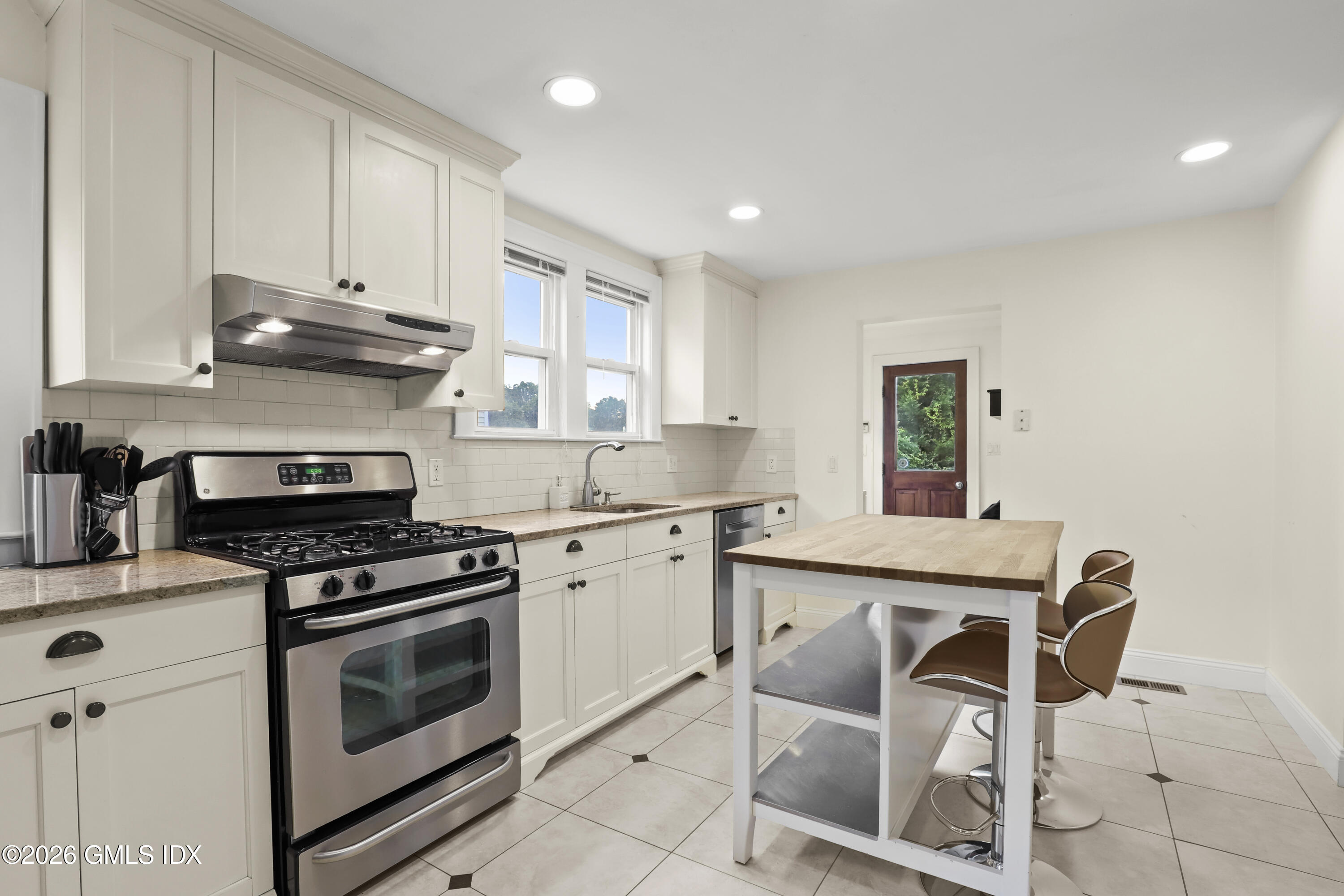 11 Rex Street Greenwich, CT 06831 - Photo 6 of 22 a kitchen with granite countertop white cabinets white stainless steel appliances and sink