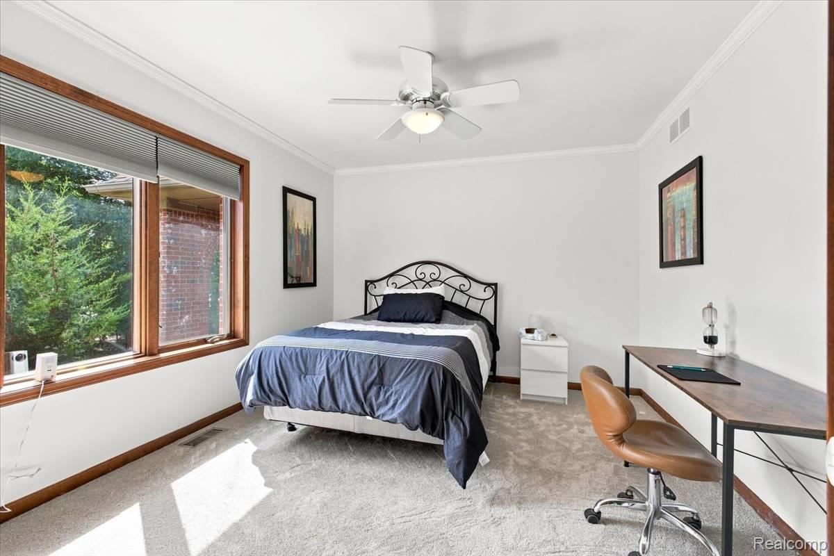8610 Ferry Road Grosse Ile, MI 48138 - Photo 34 of 55 Carpeted room featuring a ceiling fan with integrated lighting, crown molding, and wood-trimmed windows