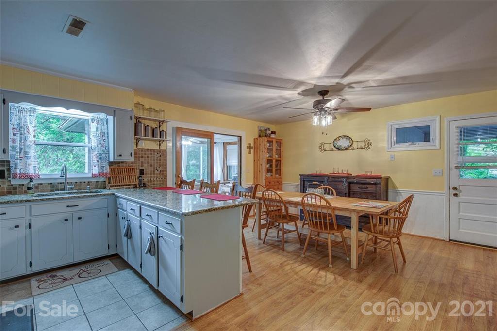 647 Blacksnake Road Stanley, NC 28164 - Photo 13 of 35 a kitchen with a stove a sink dishwasher and a dining table with garden view