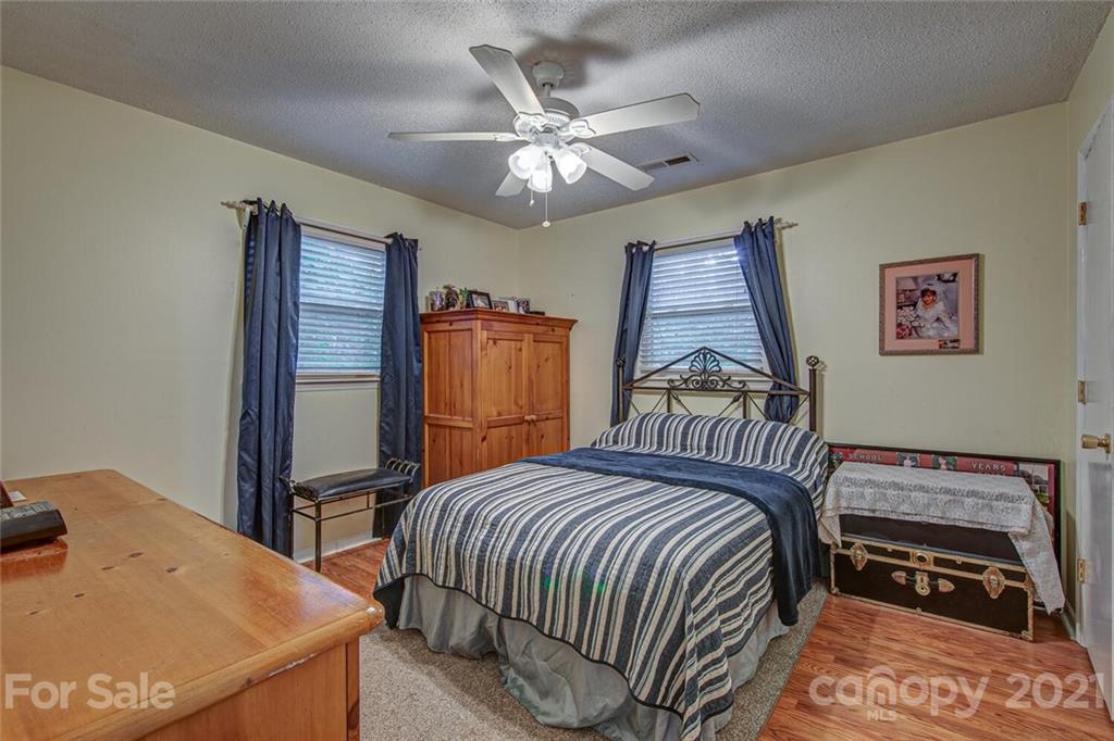 647 Blacksnake Road Stanley, NC 28164 - Photo 17 of 35 a bedroom with a bed and a chandelier