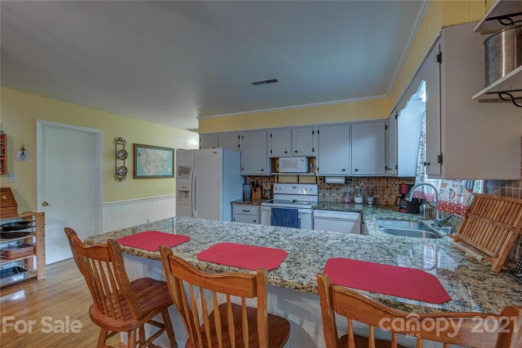 647 Blacksnake Road Stanley, NC 28164 - Photo 9 of 35 a view of kitchen with stainless steel appliances kitchen island granite countertop a dining table and chairs