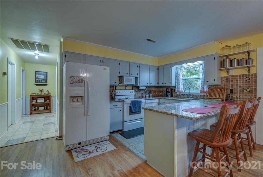 647 Blacksnake Road Stanley, NC 28164 - Photo 10 of 35 a kitchen with stainless steel appliances granite countertop a refrigerator and a stove top oven