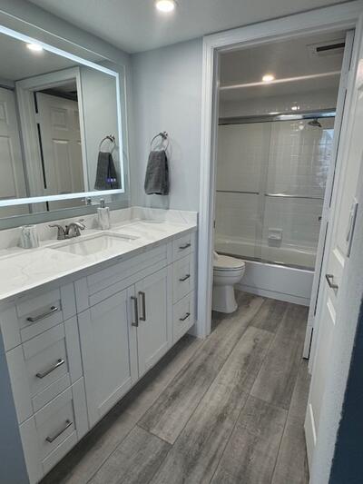 9500 South Ocean Drive, Unit 1909 Jensen Beach, FL 34957 - Photo 15 of 40 a bathroom with a double vanity sink a toilet and a large mirror