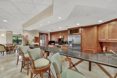 9500 South Ocean Drive, Unit 1909 Jensen Beach, FL 34957 - Photo 37 of 40 a kitchen with stainless steel appliances granite countertop table chairs refrigerator and stove