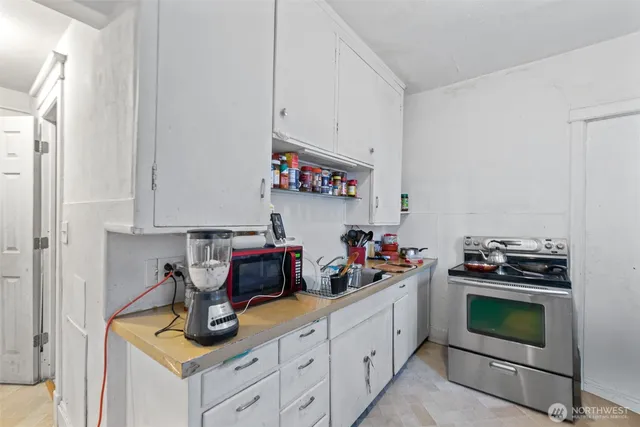 a bedroom with a bed and a kitchen