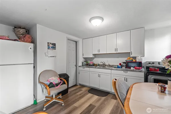 a kitchen with a refrigerator and white cabinets