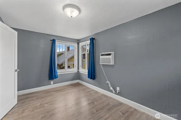 an empty room with window and hardwood