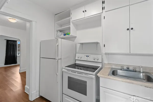 a kitchen with a refrigerator sink stove and cabinets
