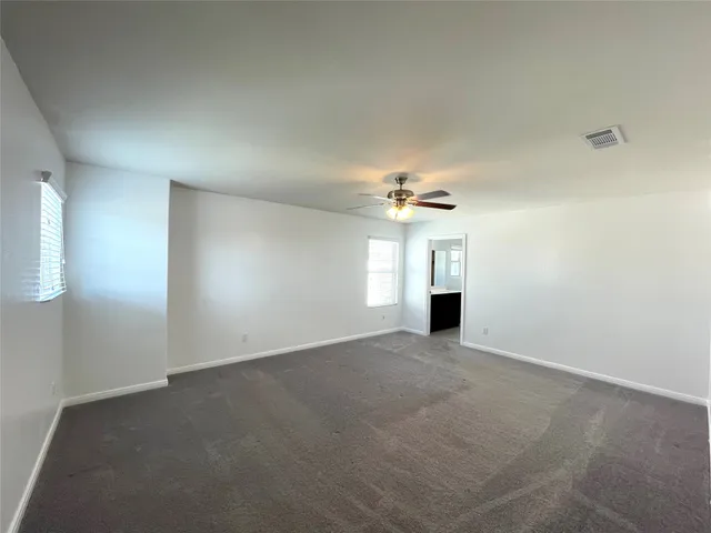 an empty room with a windows and fireplace