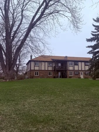 a view of a yard in front of a house with large trees