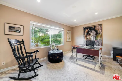 a living room with furniture a rug and a book shelf