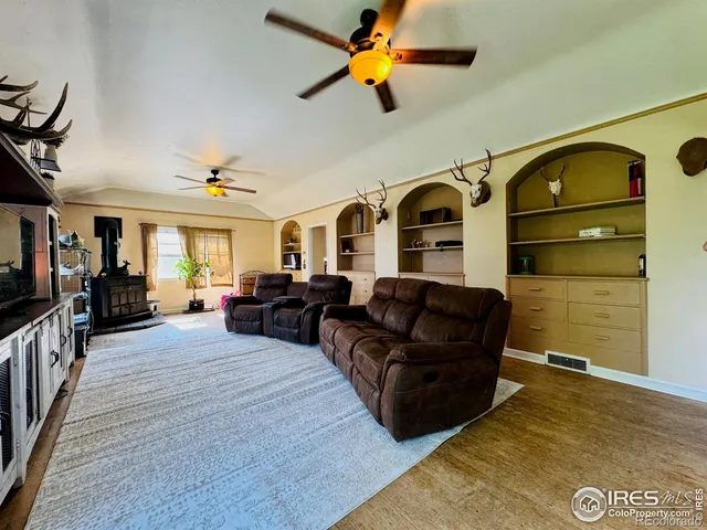 a view of a living room with hardwood floor and a ceiling fan